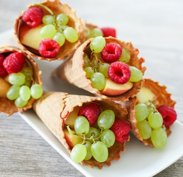 waffles cones filled with grapes, apple slices, and raspberries