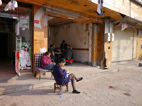woman knitting outside and others play mahjong inside at Beizheng Street in Changsha