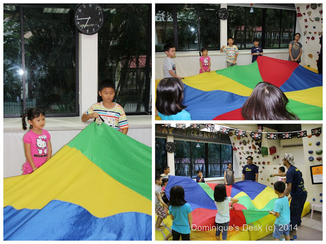 The kids playing with the parachute during the lesson.