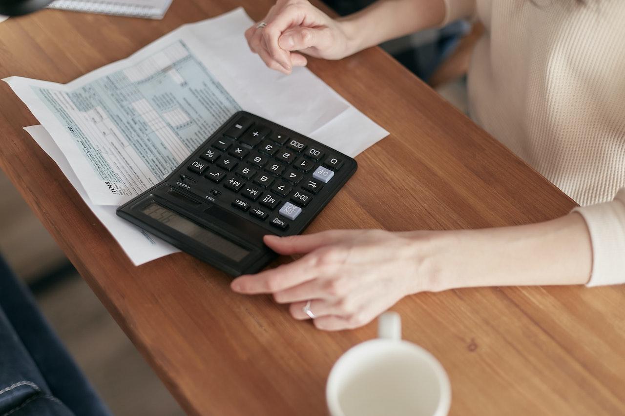 A person with a calculator preparing for Freedom Debt Relief