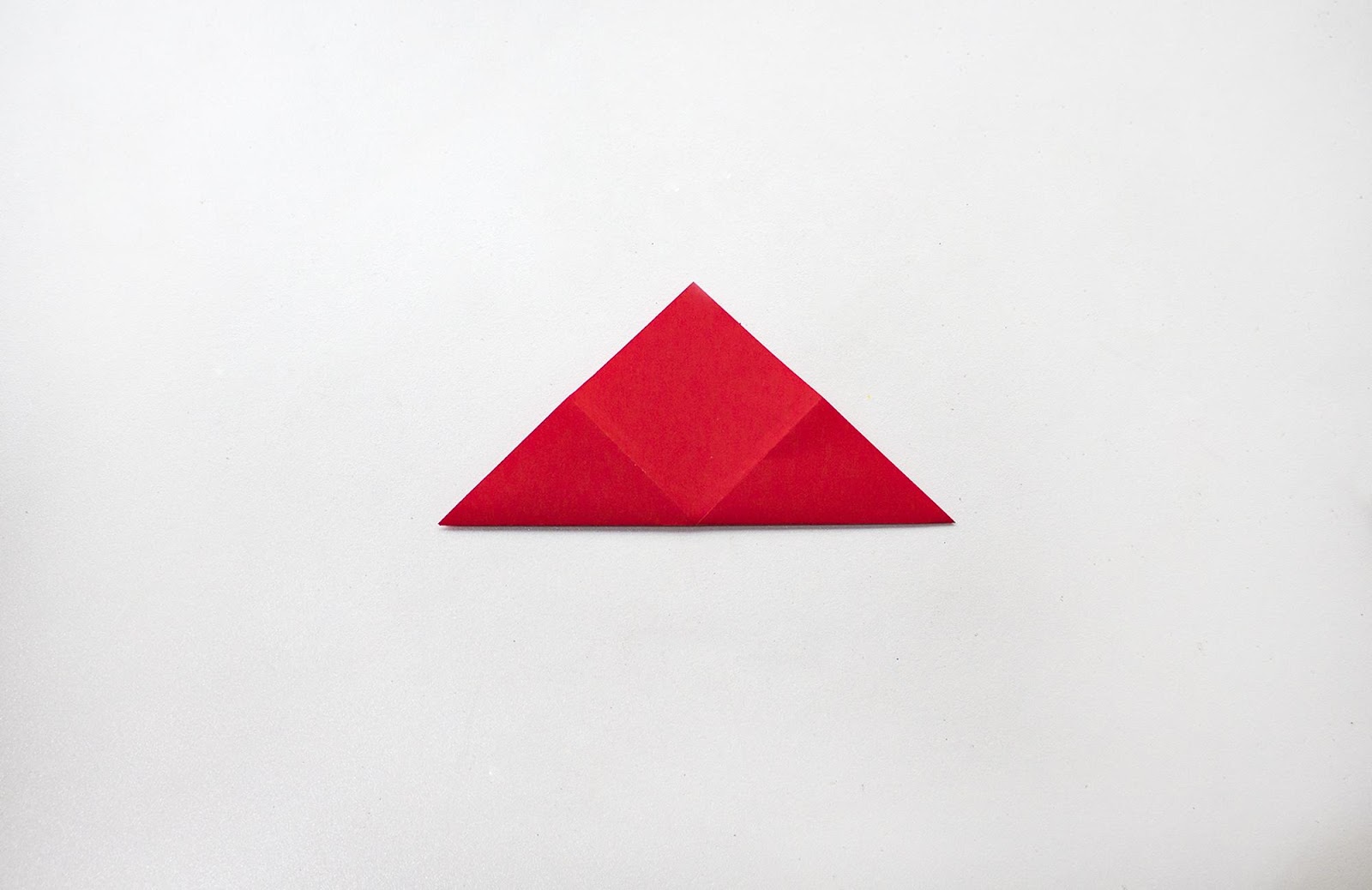 Red sheet of paper folded into triangle