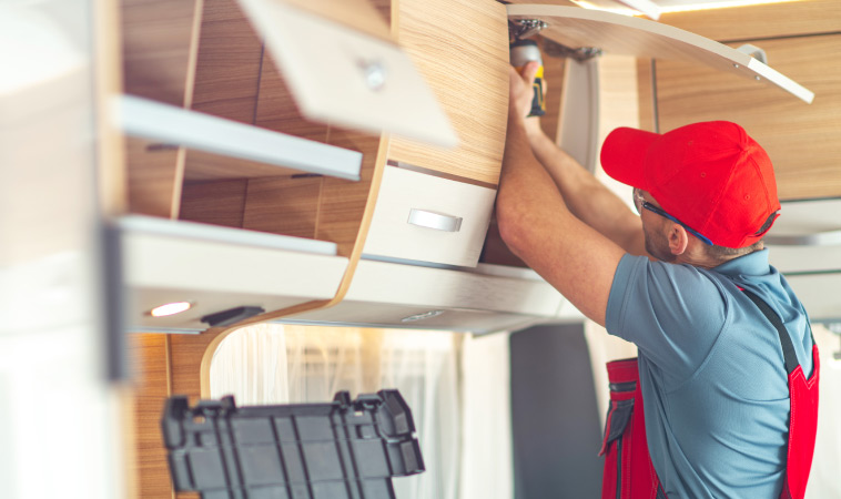 A man remodeling an RV to add storage