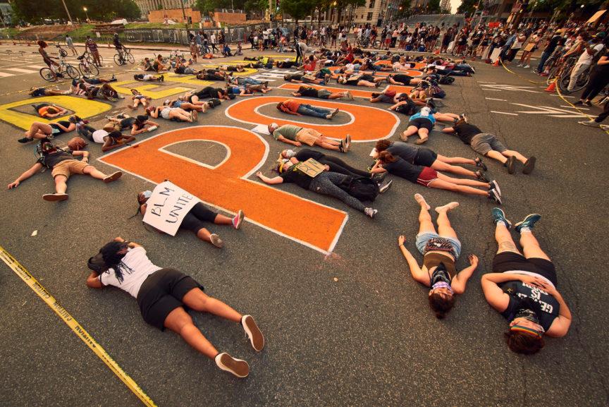 Protesters lie on the floor at a defund the police protest.