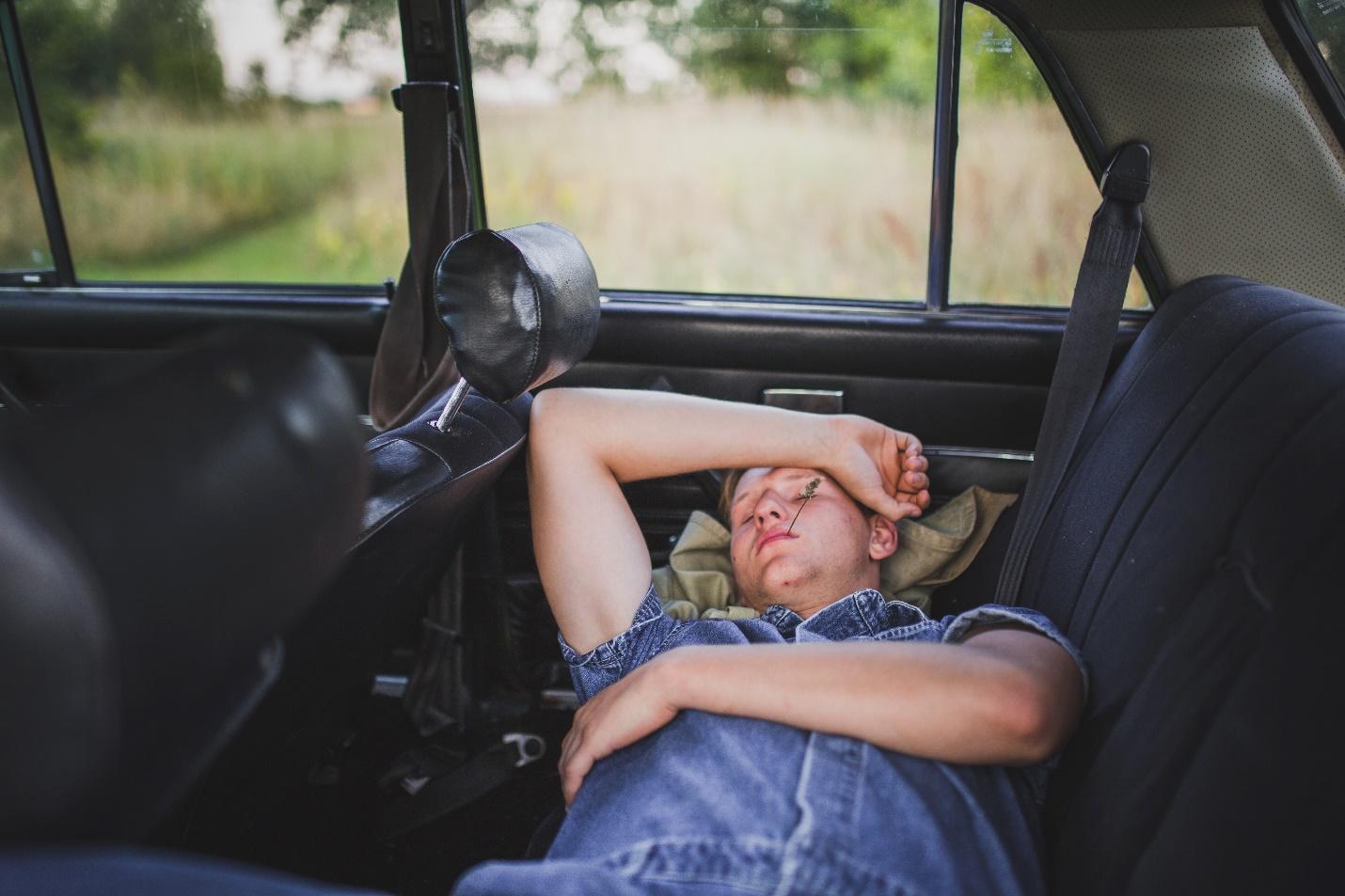 A person sleeping in a car  Description automatically generated with medium confidence