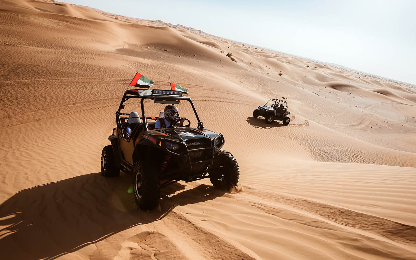 drivers driving dune buggies in uae desert