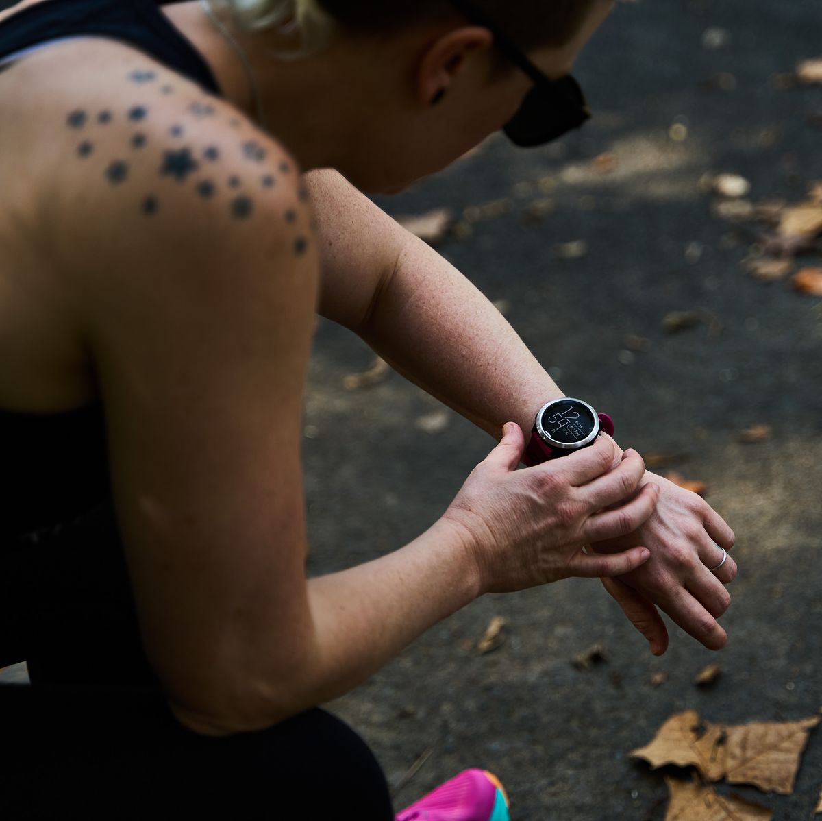 a runner checks their watch while sitting down following a workout