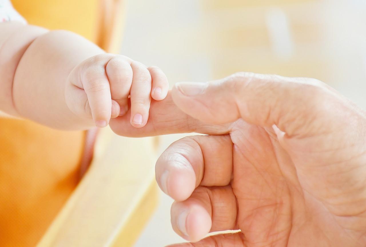 A close-up of a baby's hand being held by a person

Description automatically generated with low confidence