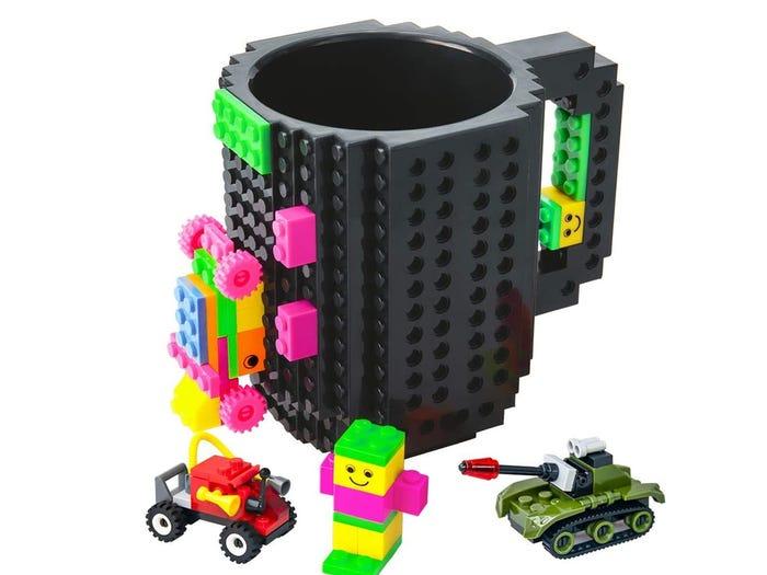 unique amazon gifts - a black Lego coffee mug with attachable Lego brick pieces