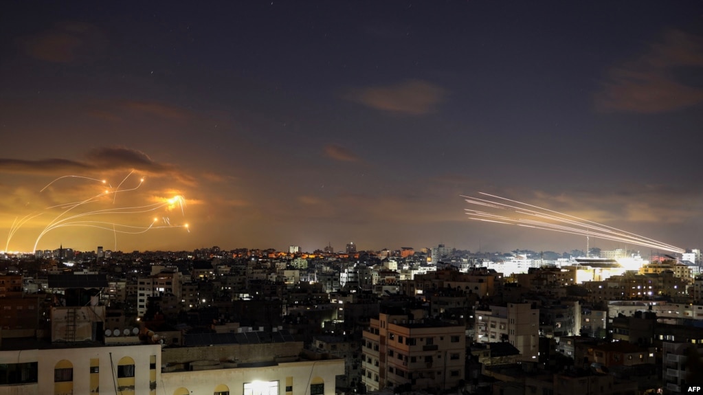 Ракети, запущені з Гази (справа), перехоплює ізраїльська система "Залізний купол" (зліва), 10 жовтня 2023. Photo by Eyad BABA / AFP