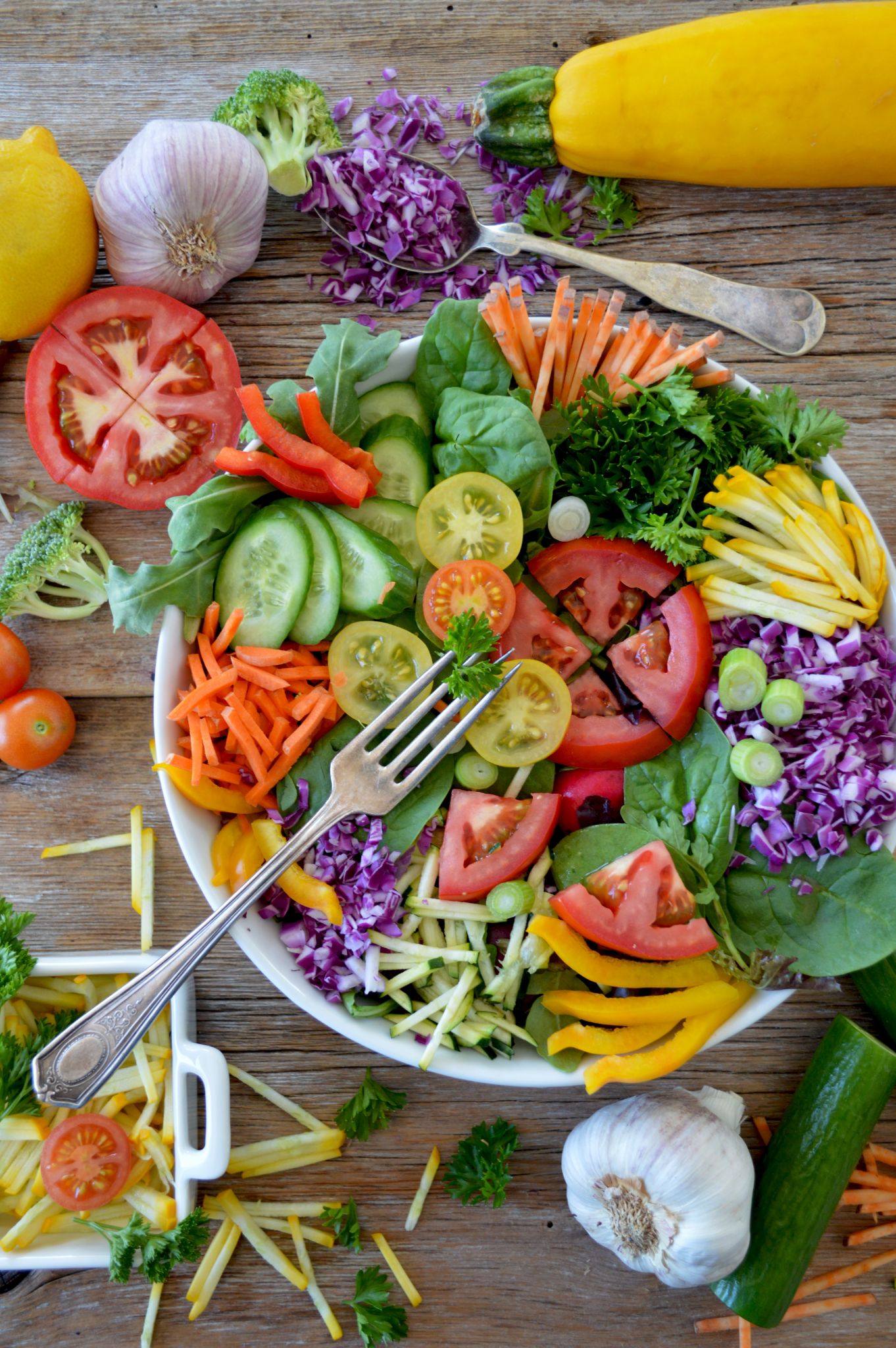 Prato repleto de verduras, legumes e frutas; alimentos onde existe presença de vitamina C. 