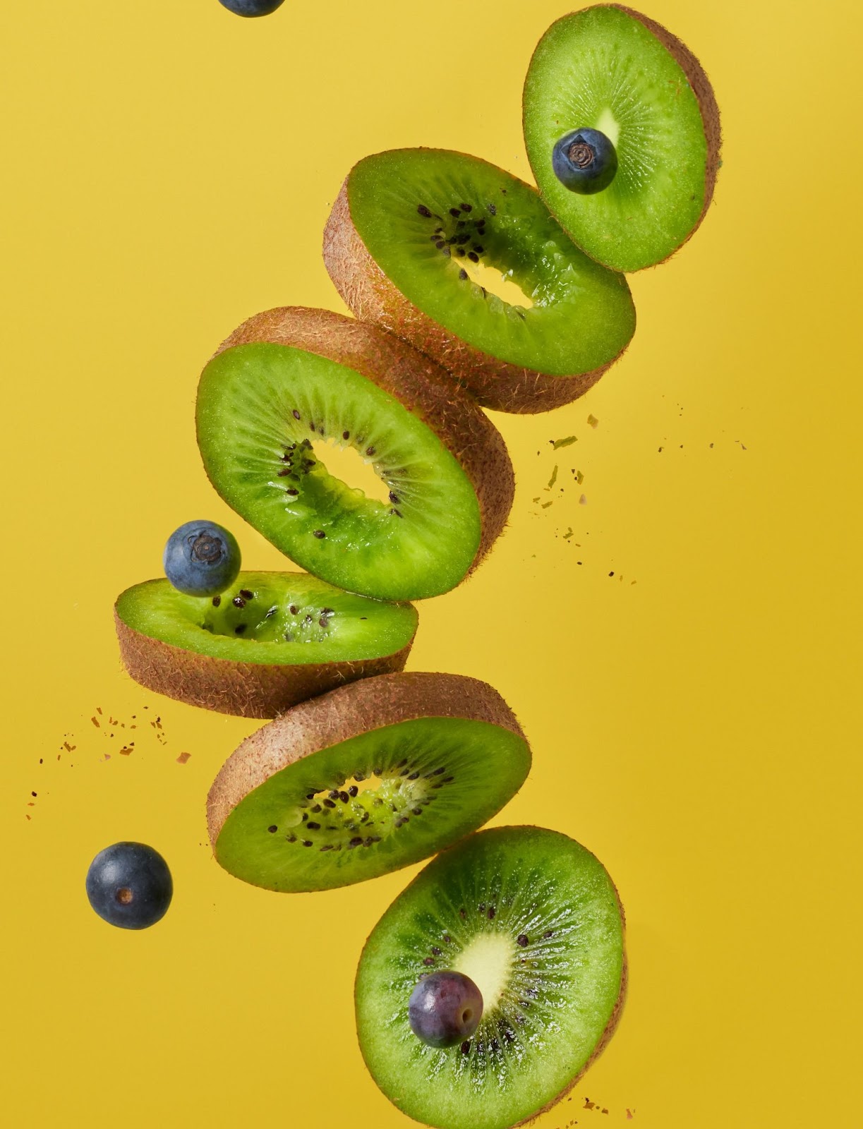 Slices of green Kiwi fruit in air. 