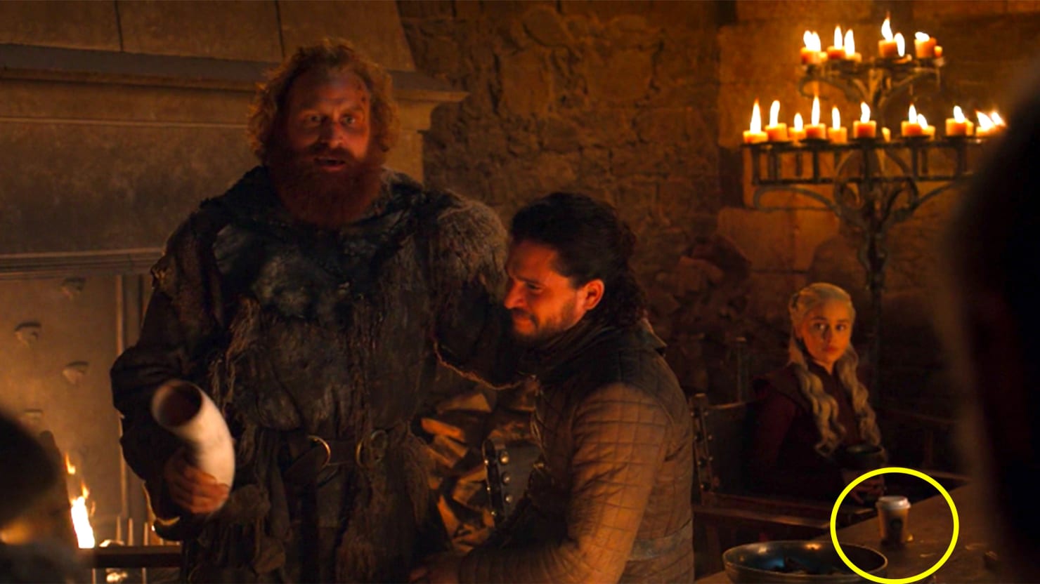 A scene of the renowned series Games of Thrones where one can see a starbucks coffee cup on the table, despite the ancient theme of the show.
