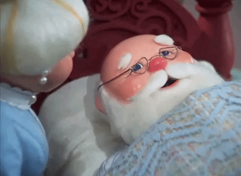 Mrs. Claus putting a thermometer in Satna's mouth.