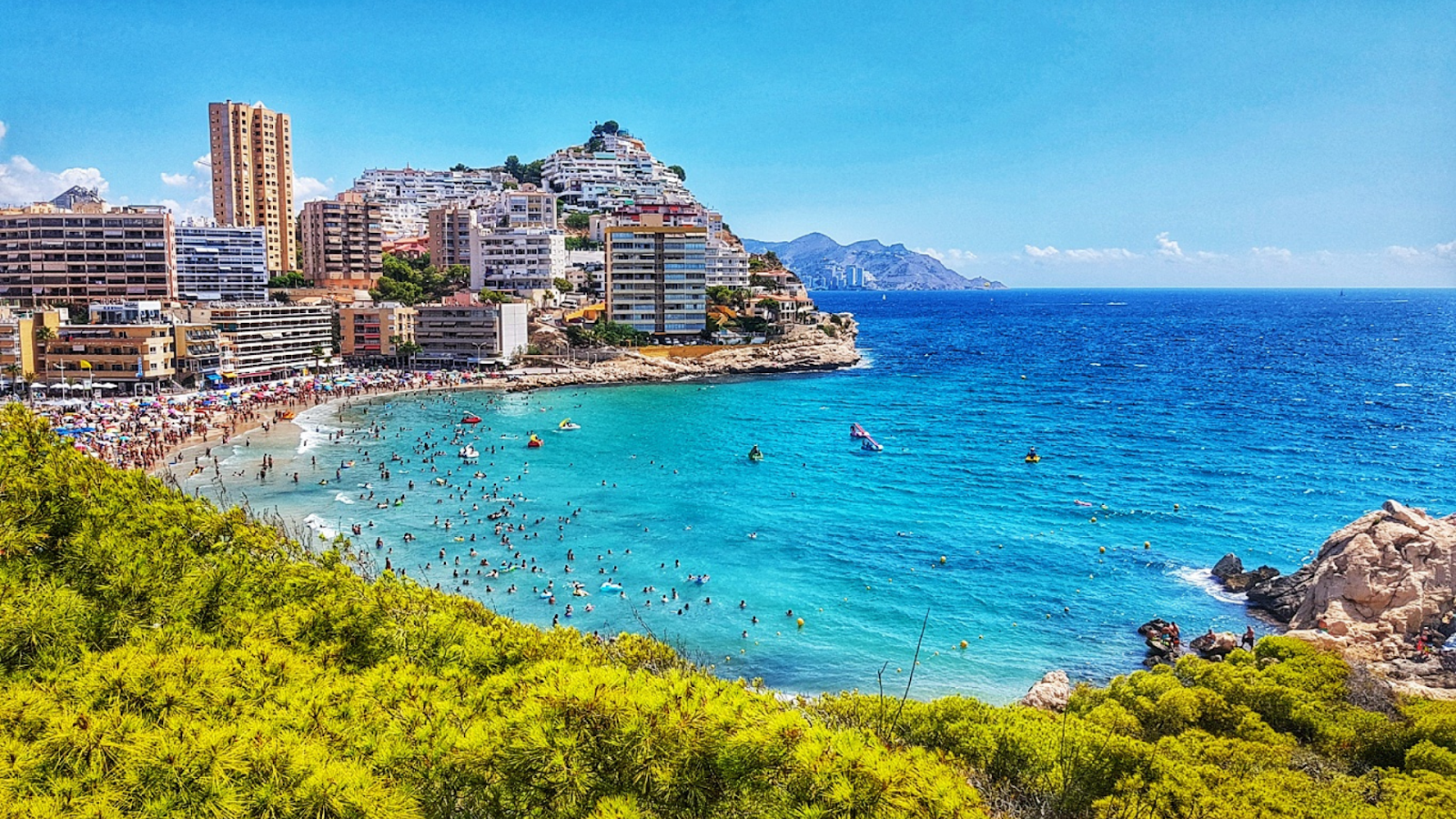 Cala de Finestrat with the beach and city in the background on a sunny day.