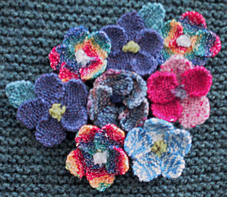 colorful knitted flowers on garter stitch knitted background