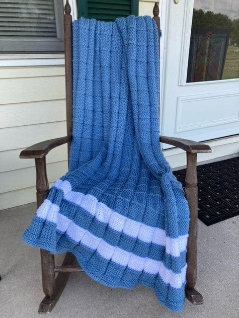 blue loom knit blanket with stripes on rocking chair