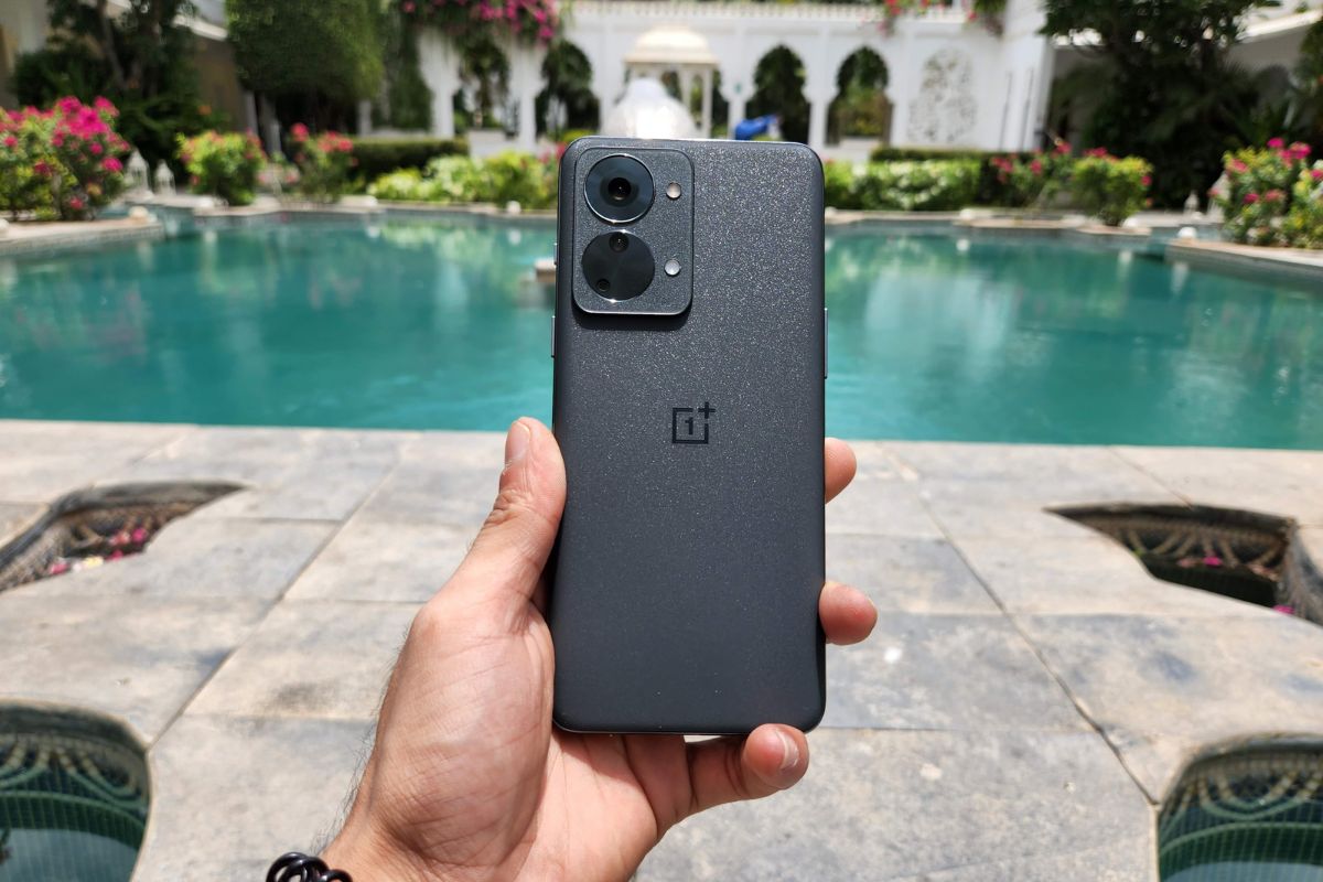 This image shows the OnePlus Nord 2T 5G in the hands of a man under the sunshine.