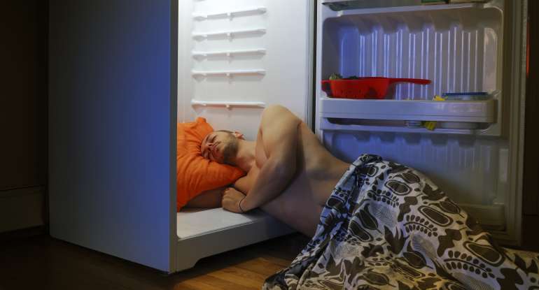 Man sleeping with head in refrigerator 