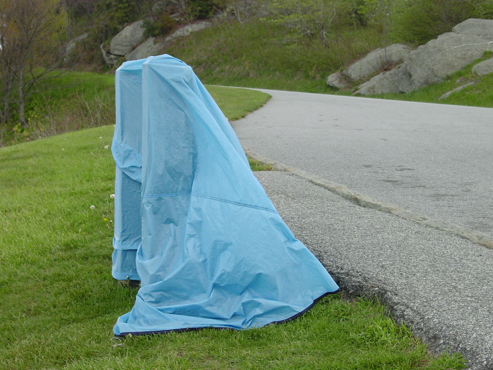 A blue tarp over a roadside sign.