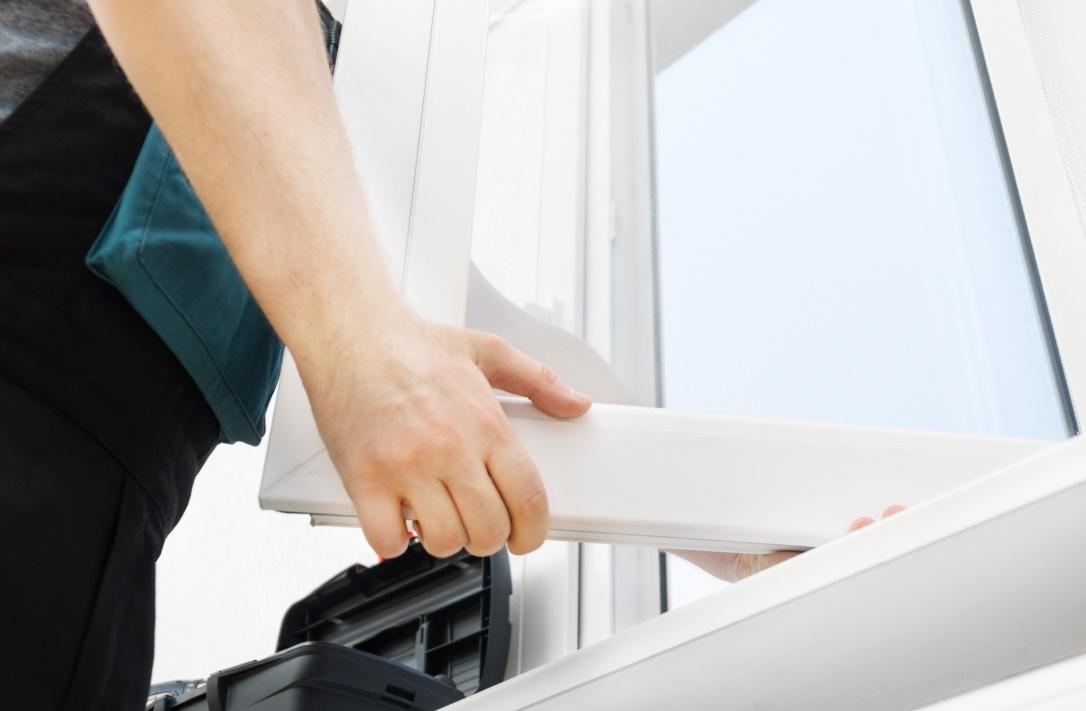 WeServe | a man holding a window panel with a toolbox on the side
