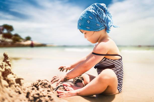 Cute girl building sand castle on tropical beach Cute girl building sand castle on tropical beach  kids making sand castle stock pictures, royalty-free photos & images