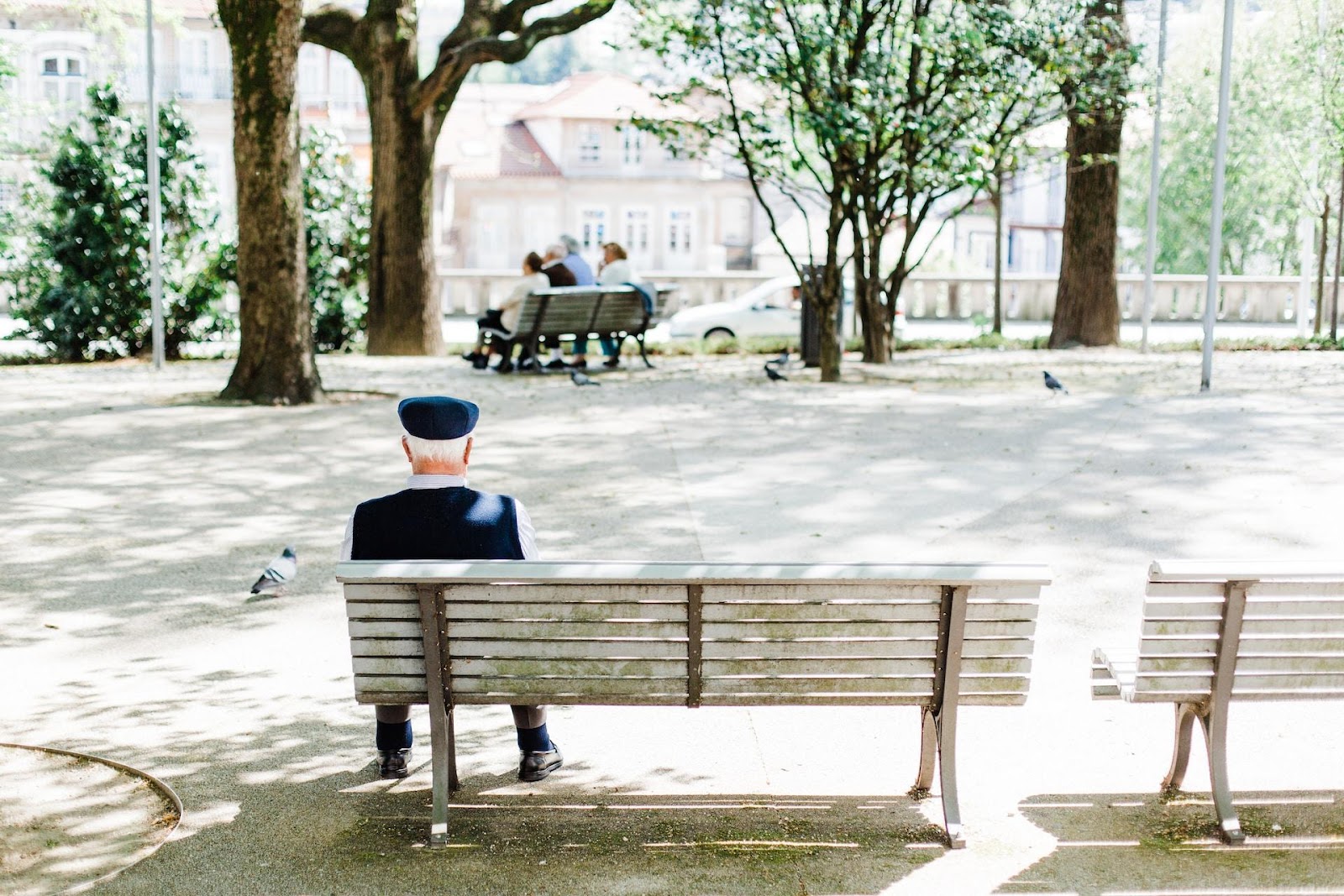 An elderly person sitting down on a bench