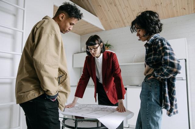 A group of people looking at a paper

Description automatically generated with low confidence