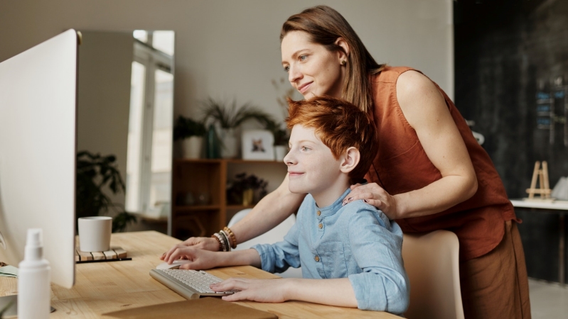 a mother helps her son with home learning