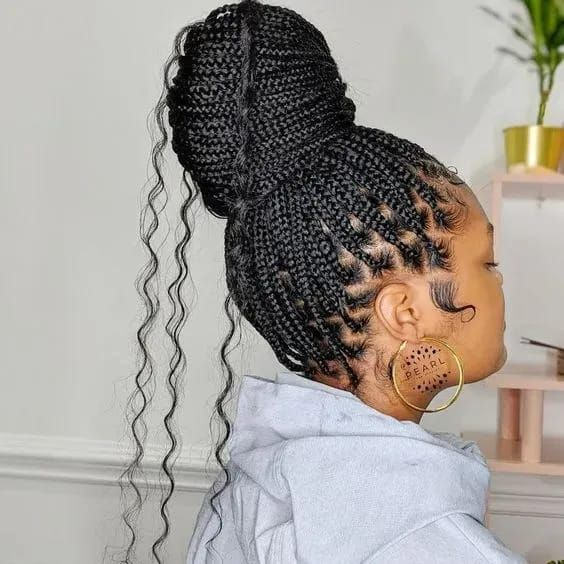 Side view of lady showing off her braids wrapped in a bun with curls 