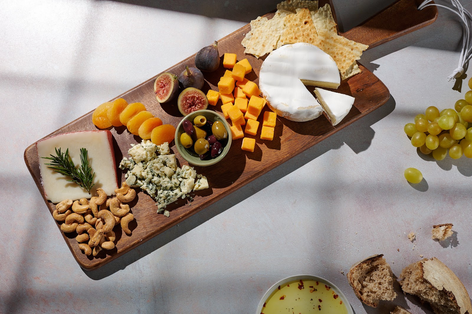 Professional food photo of full cheese platter and soft window lighting.