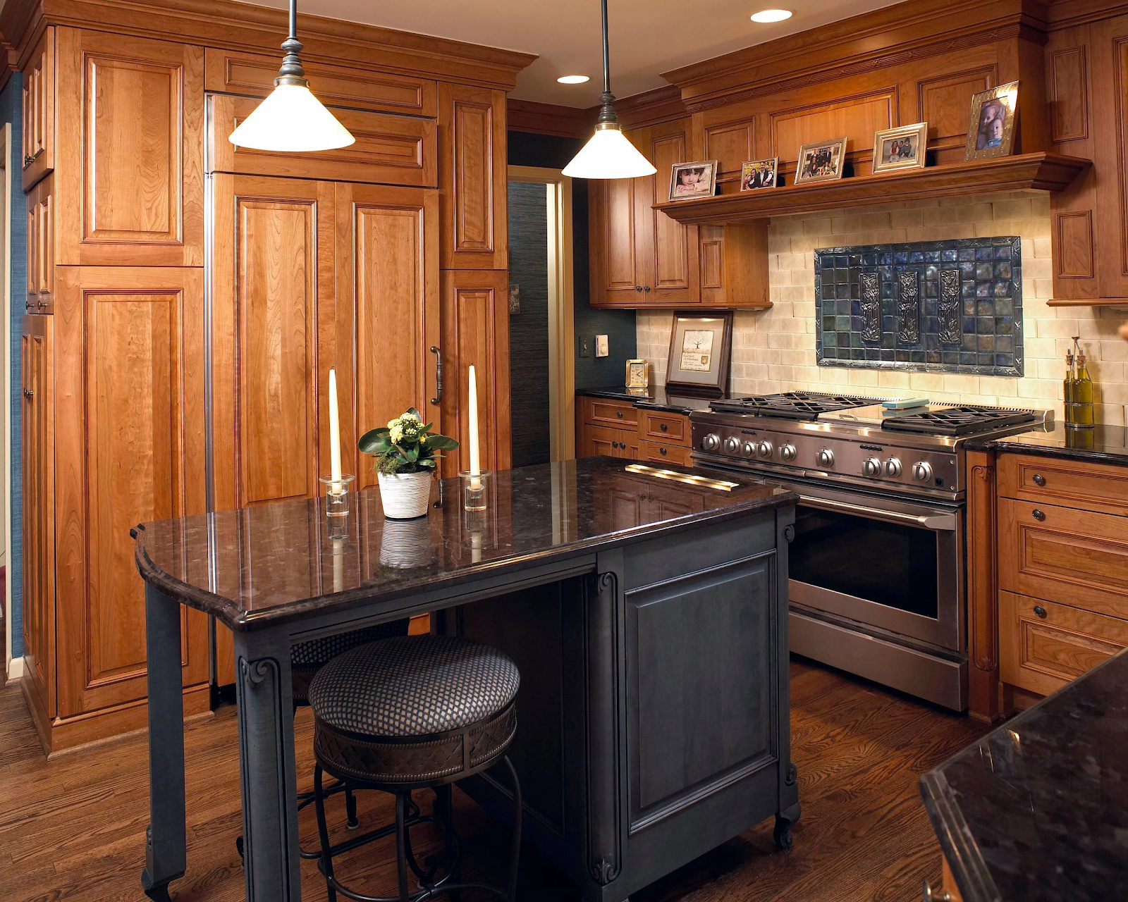 small traditional kitchen with medium brown engraved cabinets, black center island with black marble countertops. the rich details distract the eye from the small space