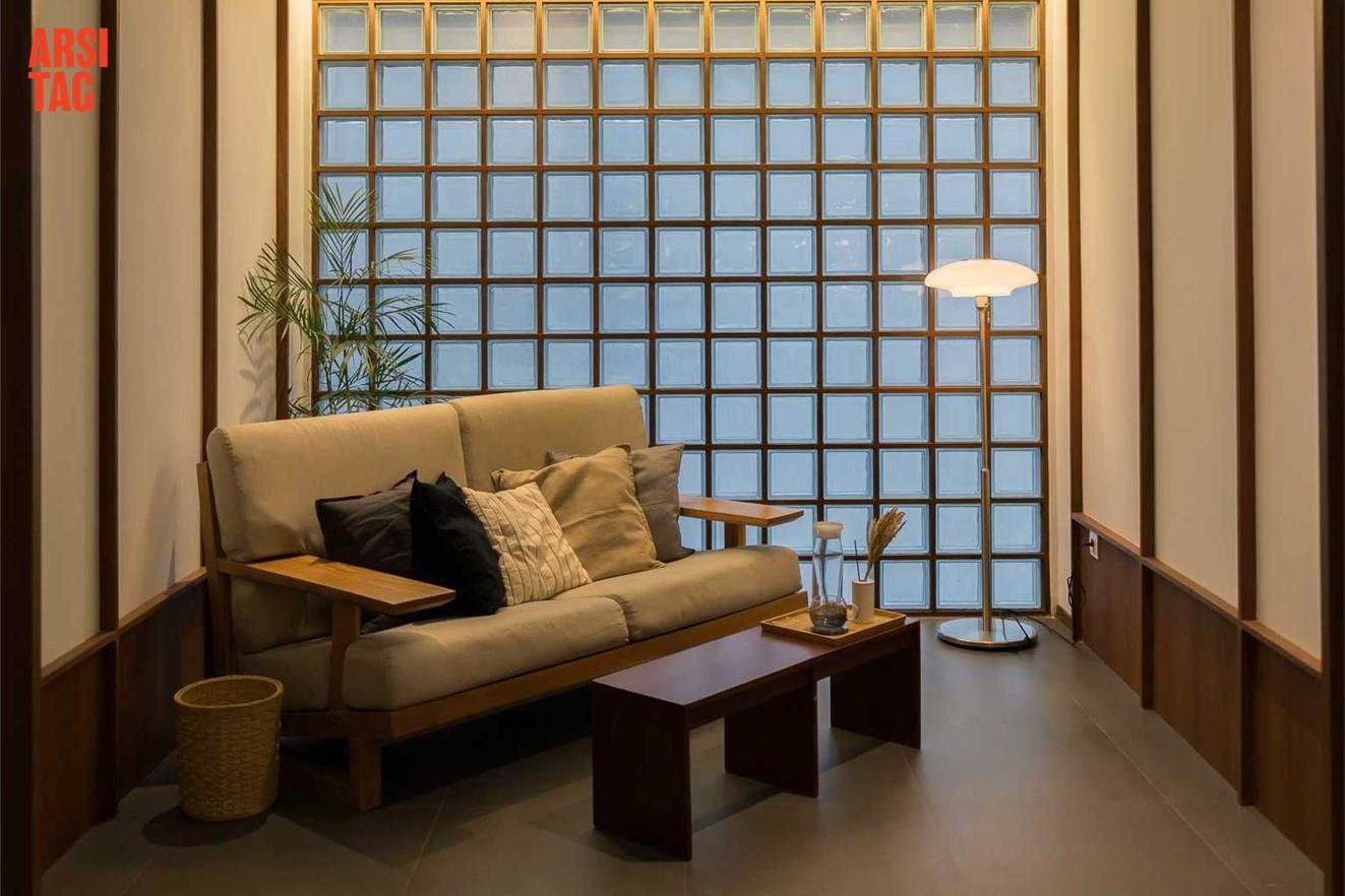 Sofa di ruang keluarga dengan latar belakang glassbox, karya Birka Loci via Arsitag  