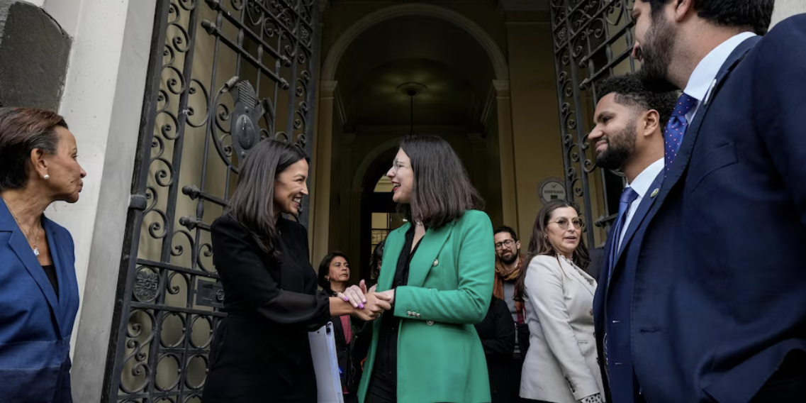 Alexandria Ocasio-Cortez (D-NY) shakes hands with Mayor Iraci Hassler in Santiago, Chile, on August 17, 2023. (AP Photo/Esteban Felix)