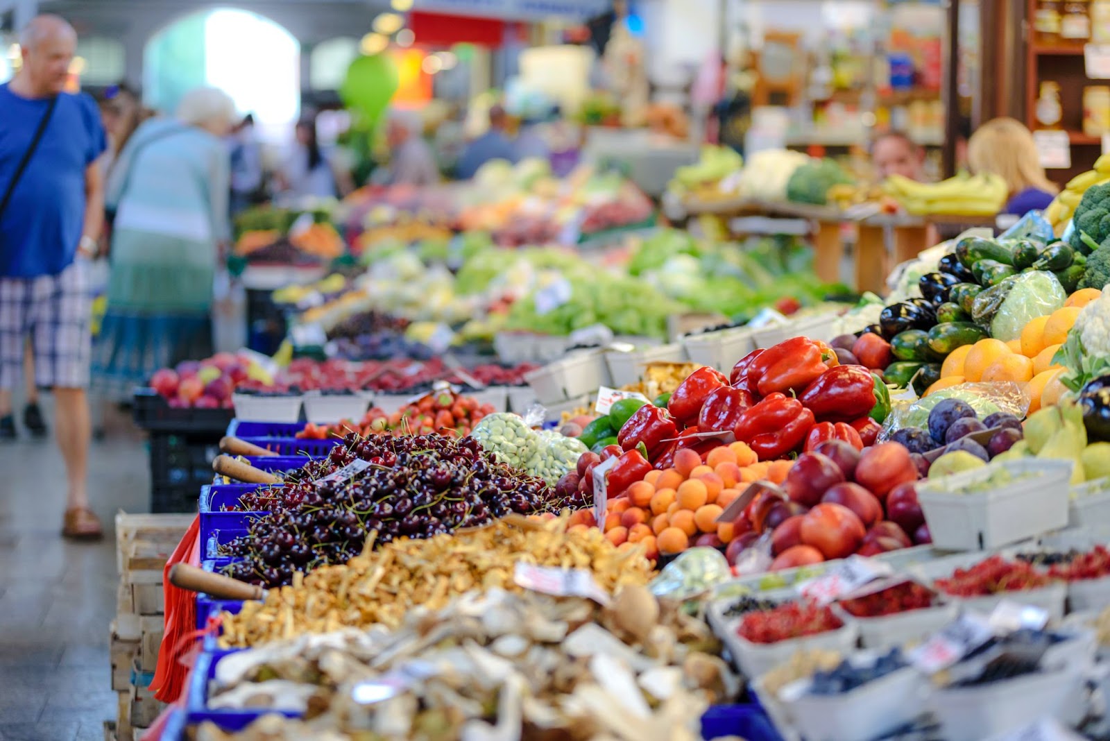 Various fresh vegetables are displayed on a grocery store stall.