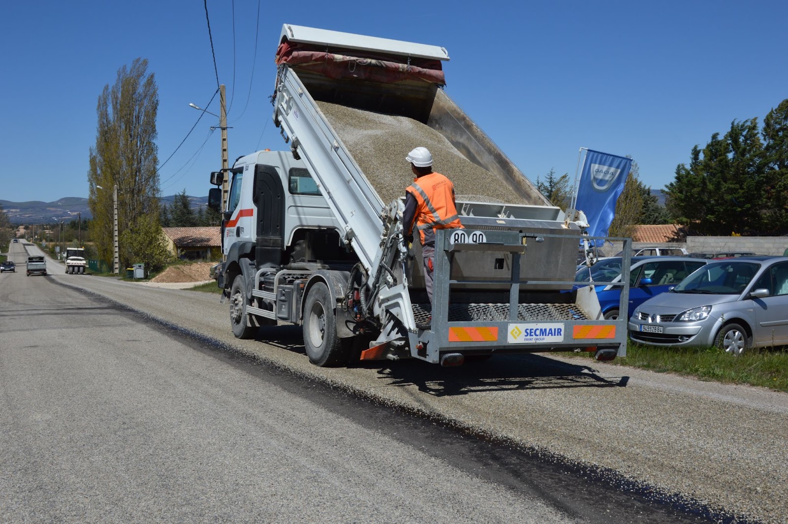 A dump truck dumping out raw materials on the ground