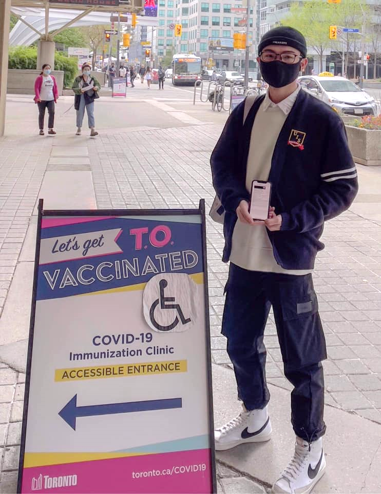 A person wearing a mask and holding a sign

Description automatically generated with medium confidence