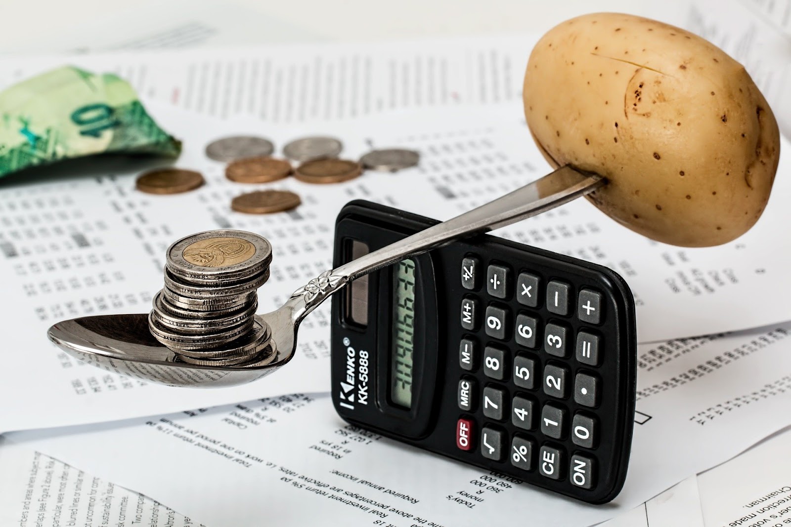 Calcular o custo dos funcionários é essencial à saúde financeira da sua empresa. Na imagem aparece uma calculadora com uma colher e uma batat, que representa o equilíbrio financeiro.