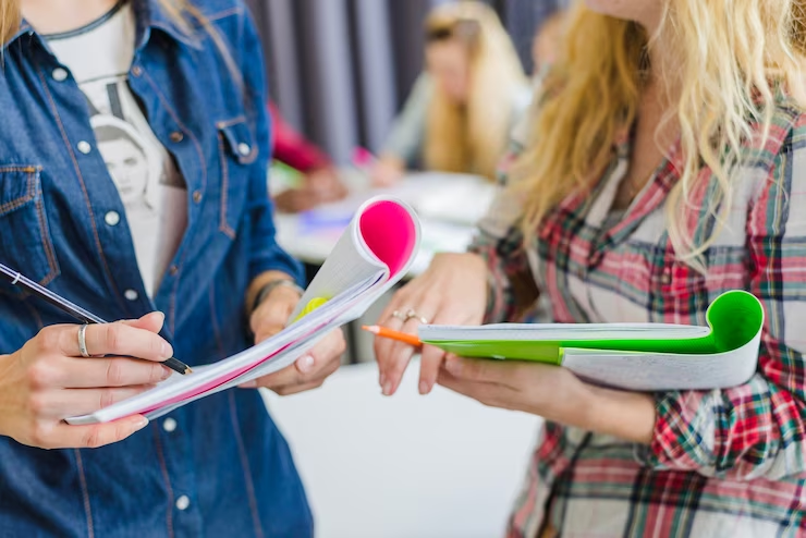 A group of diverse women working in a coworking space, taking notes and discussing extracurricular activities for medical school applications.