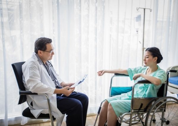 patient in wheelchair consulting with a doctor