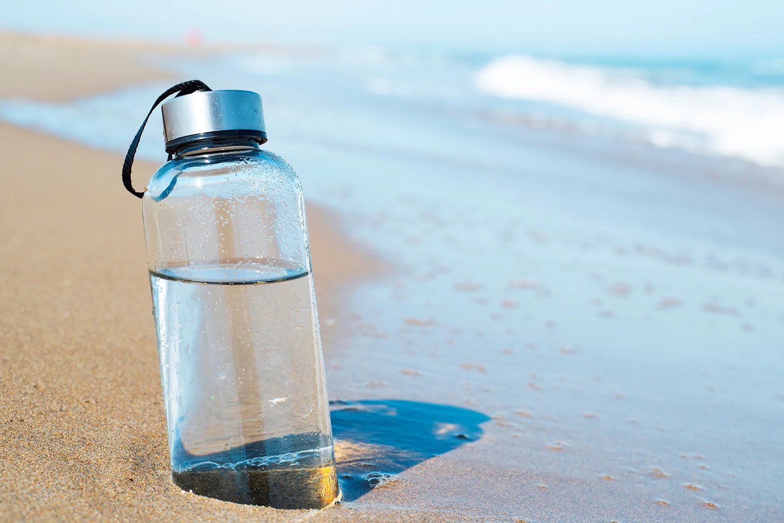A reuseable water bottle by the beach 
