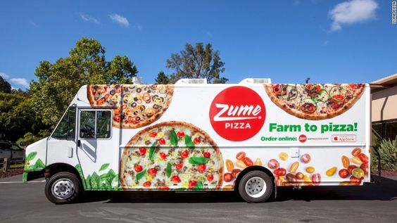A mail delivery truck completely wrapped in visually appealing advertisements for Zume Pizza. The ads showcase enticing images of various pizzas, while the text boldly states 'Farm to Pizza' and includes a call to action, urging viewers to 'Order Online on the App.' 