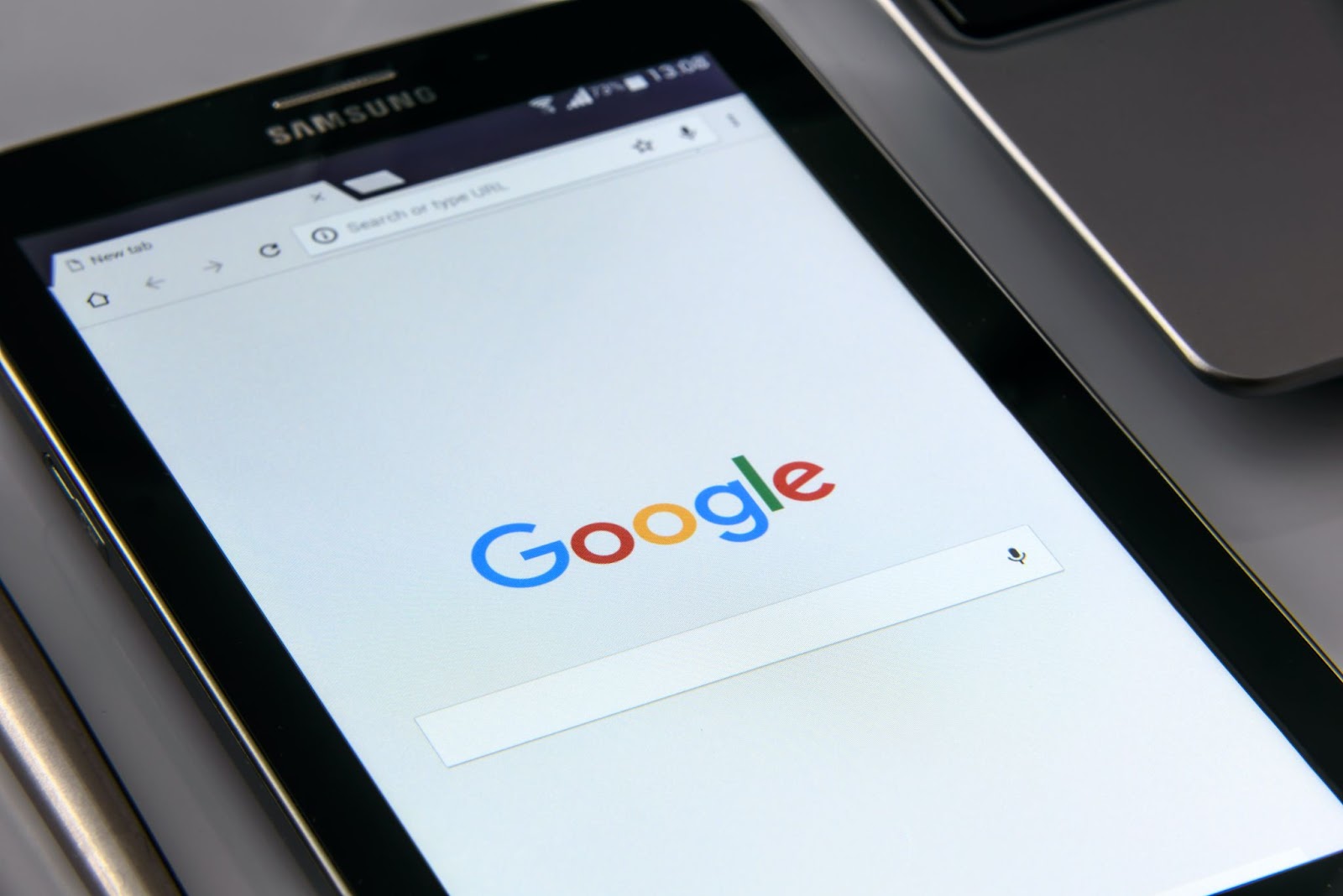 what is seo google; Google's logo and search bar displayed on a tablet;