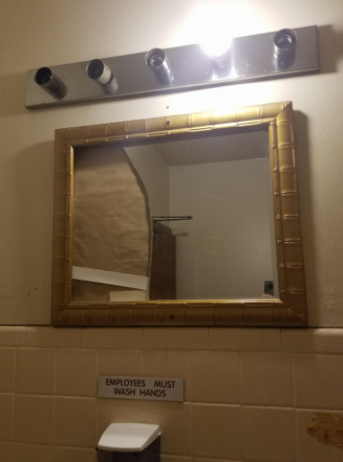 Image of a broken mirror in a public restroom