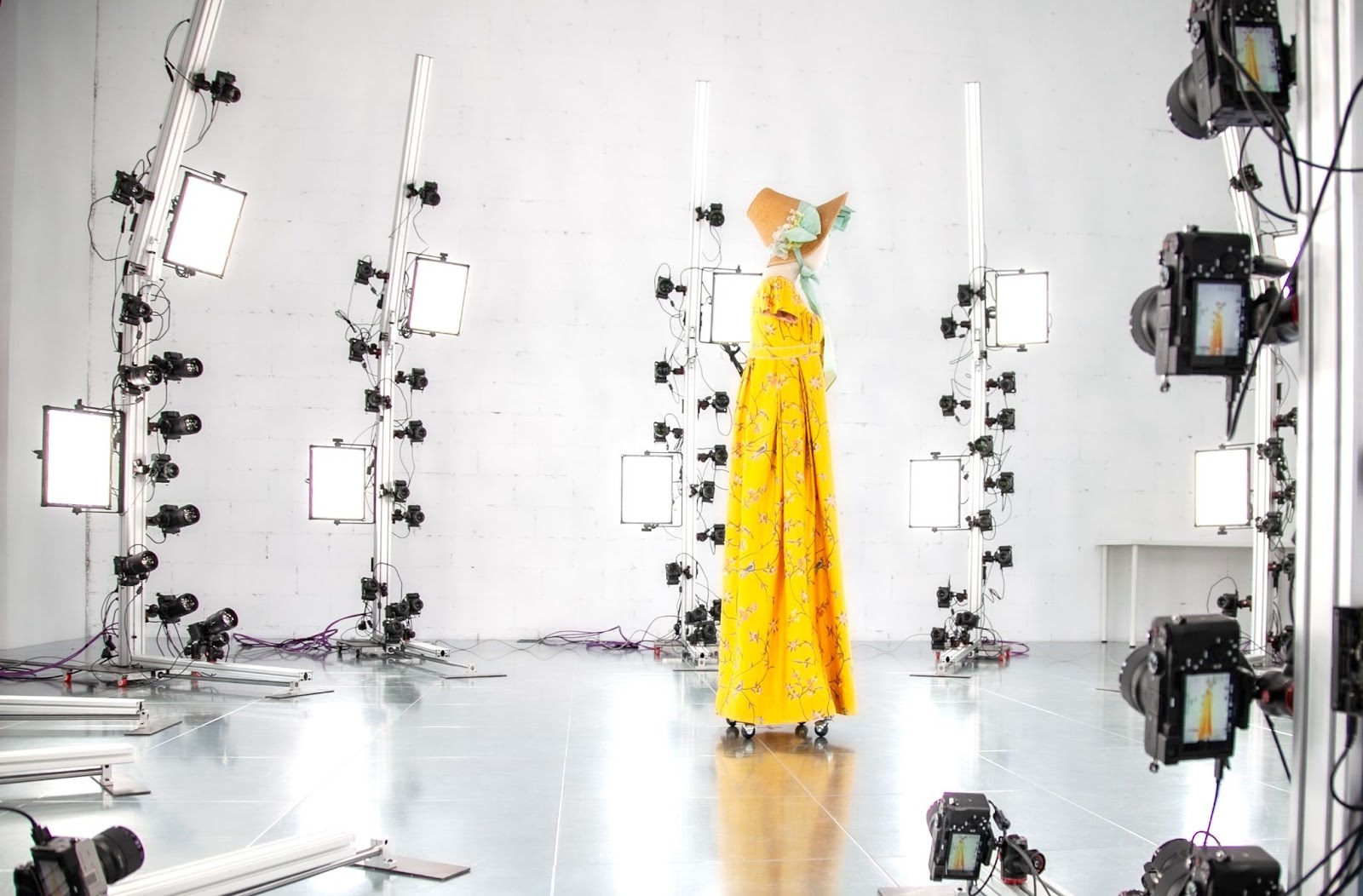 A long stand holds a hat and coat, placed in the center of the room, and is surrounded by cameras. Image courtesy of Peris Digital.
