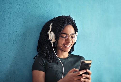 Woman in Black Crew Neck T-shirt Wearing White Headphones