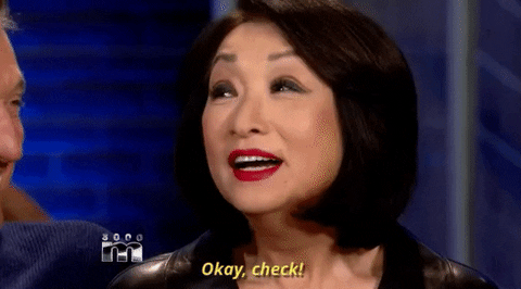 An Asian woman making a “check mark” gesture with her finger saying “okay check!”