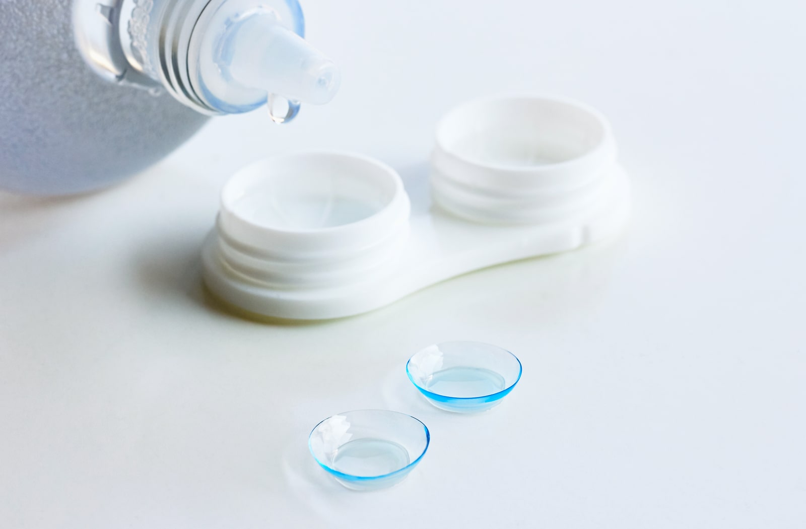 Specialty contacts sitting next to a bottle of contact solution and a contact lens case