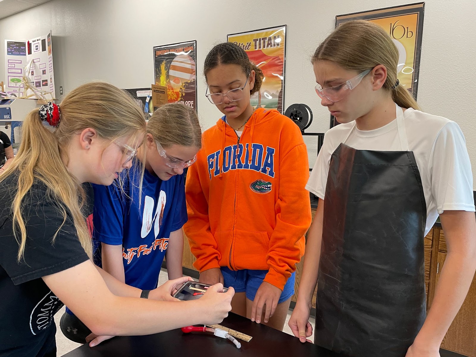 Image of several (undisclosed) students working through enzyme experiment in a 1-g environment. 