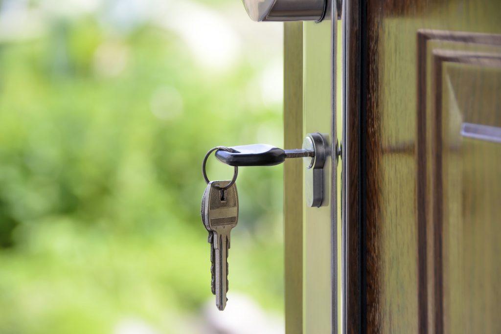 A view of a key inside a keyhole on a wooden door.