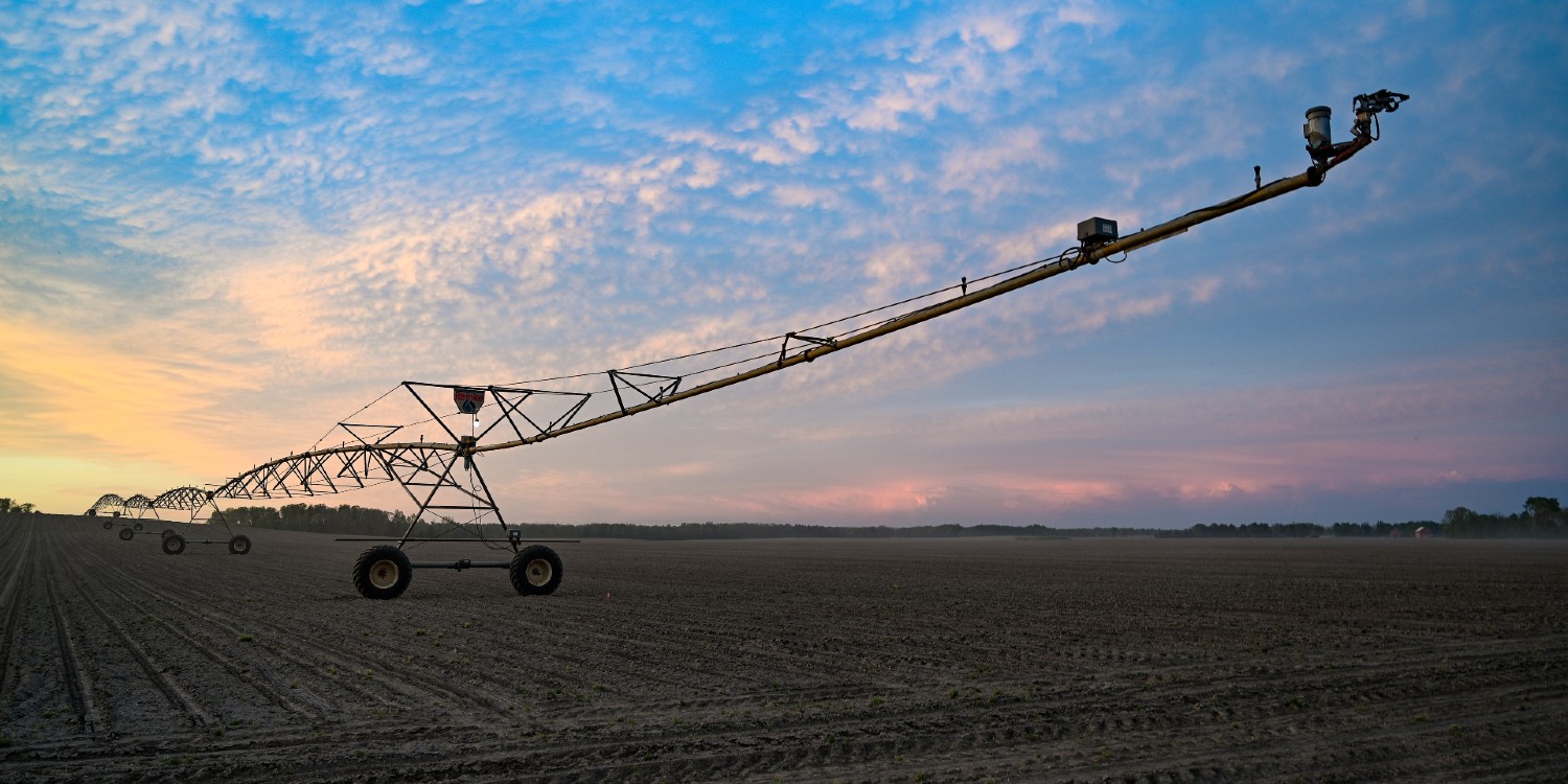 sunrise image of an irrigation boom arm on a ploughed field